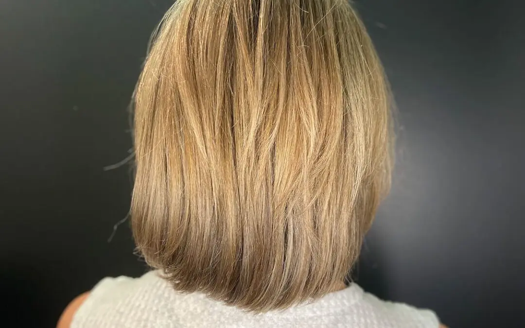 View from the back of a dimensional honey blonde bob haircut with soft texture and an inward beveled finish, styled at Sunday Salon in Raleigh, NC.