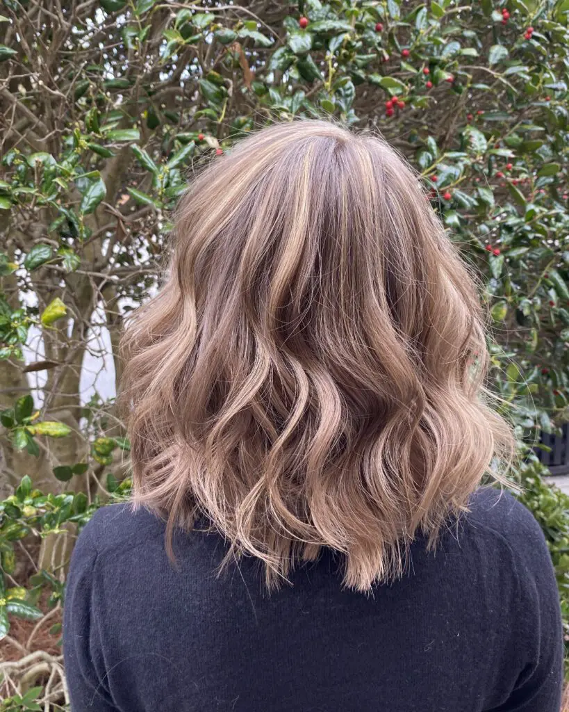 Back view of a shoulder-length wavy lob featuring a custom dusty rose gold and bronde balayage with a seamless shadow root, styled at Sunday Salon in Raleigh, NC.