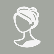 Silhouette of a person with hair tied up in a bun against a gray background. The image evokes the simplicity and elegance you'd find at the best hair salon Cary NC has to offer, serving as a generic profile icon representing a figure without any distinctive facial features.