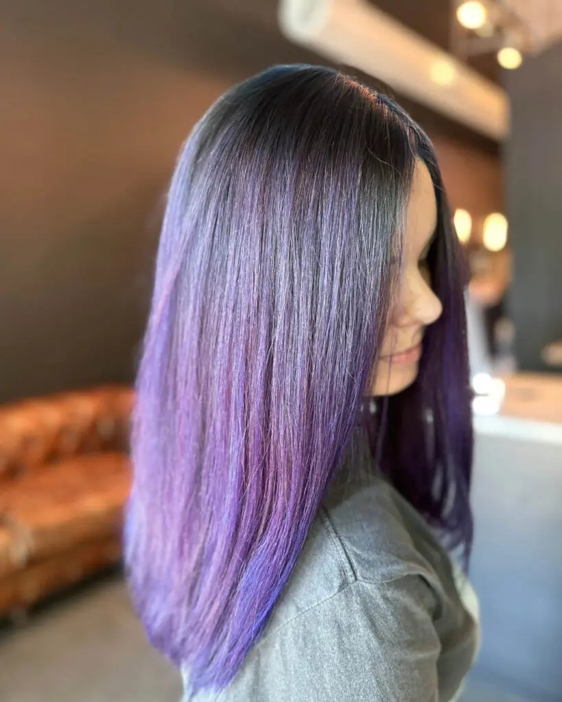 Sleek Vivid Amethyst Purple Color Melt with a Deep Shadow Root Side profile of a client showcasing sleek, medium-long straight hair with a vivid metallic purple color melt and deep shadow root, custom colored by Lisa Edwards at Sunday Salon in Raleigh, NC.