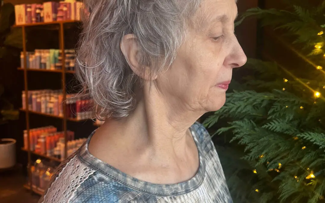Side profile of a client showcasing a short, textured silver crop haircut with natural wavy definition and a wispy fringe at Sunday Salon in Raleigh, NC.