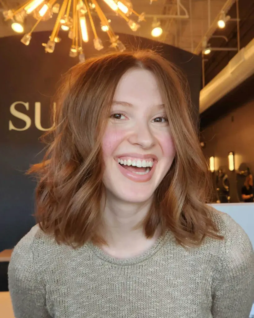 Soft Auburn Copper Lob with Effortless Lived-In Waves Smiling woman with a collarbone-length soft auburn copper lob haircut styled in loose, lived-in waves by Jess Mallard at Sunday Salon in Raleigh, NC.
