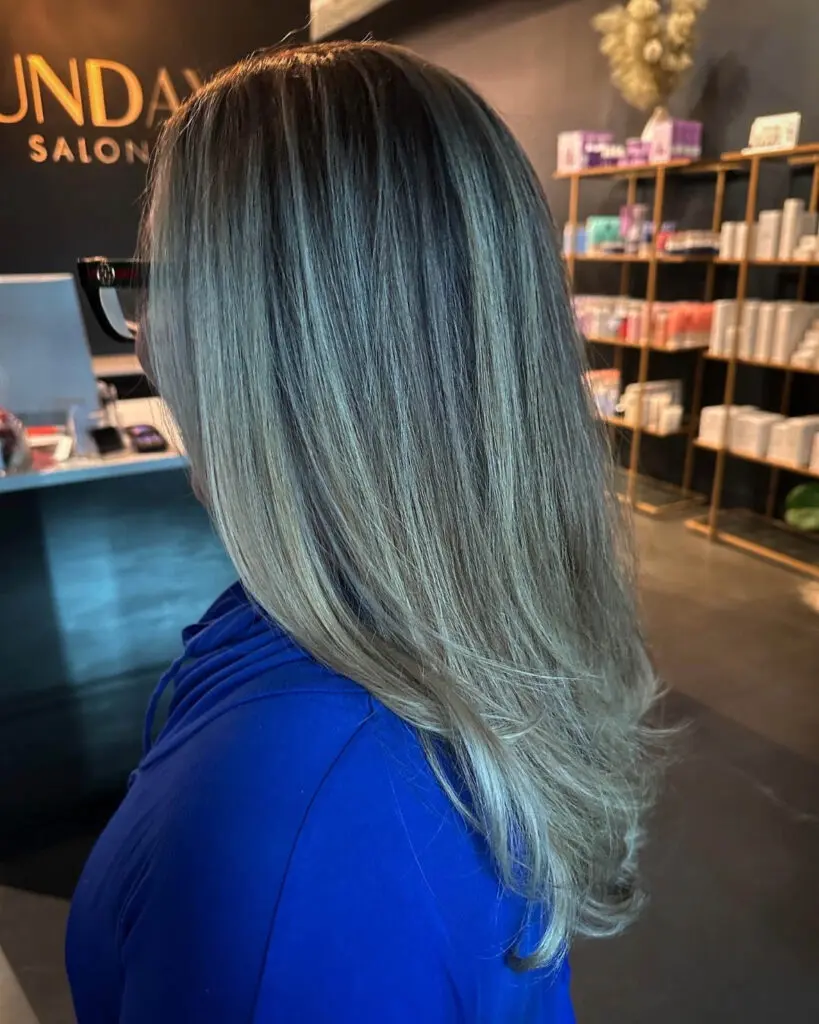 Sleek Cool-Toned Ash Bronde Balayage with Softly Flipped Ends Side profile of a client showcasing long, dimensional cool-toned ash bronde hair with finely woven highlights, styled in a smooth blowout at Sunday Salon in Raleigh, NC.