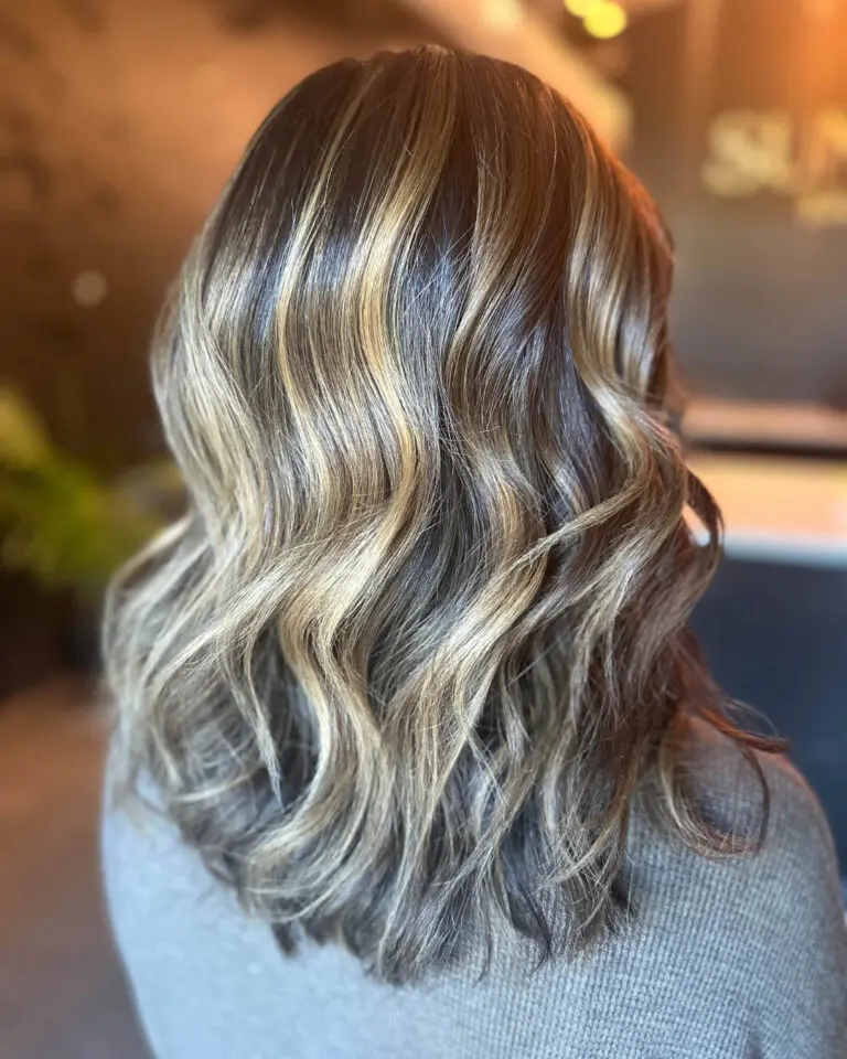 Transform your dark hair with a high-contrast golden blonde balayage and polished waves at Sunday Salon, Raleigh Iron Works. Book your custom color today!