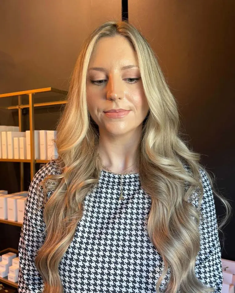 A client at Sunday Salon in Raleigh displaying ultra-long, dimensional blonde hair styled in soft, glamorous waves. The bright, face-framing highlights pop against a subtle, lived-in base, showcasing the elegant flow of the cascading layers and healthy volume.