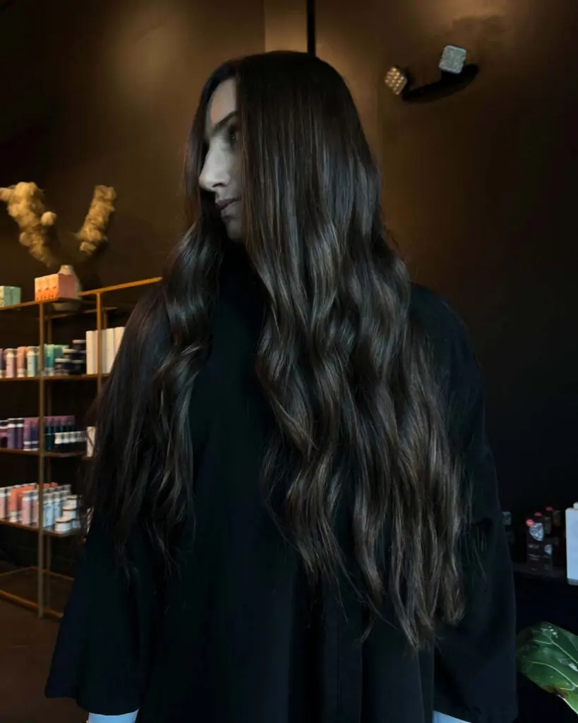 Ultra-Long Deep Espresso Brunette with Effortless Cascading Waves A client with ultra-long deep espresso brunette hair styled in effortless cascading waves with subtle warm dimension, created at Sunday Salon in Raleigh.