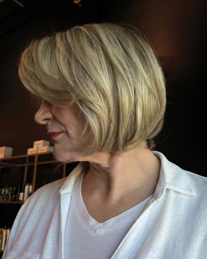 Classic Chin-Length Blonde Bob with Soft Volume A chic, chin-length blonde bob haircut styled with a smooth, voluminous blowout and sweeping face-framing layers, crafted by an expert stylist at Sunday Salon in Raleigh.
