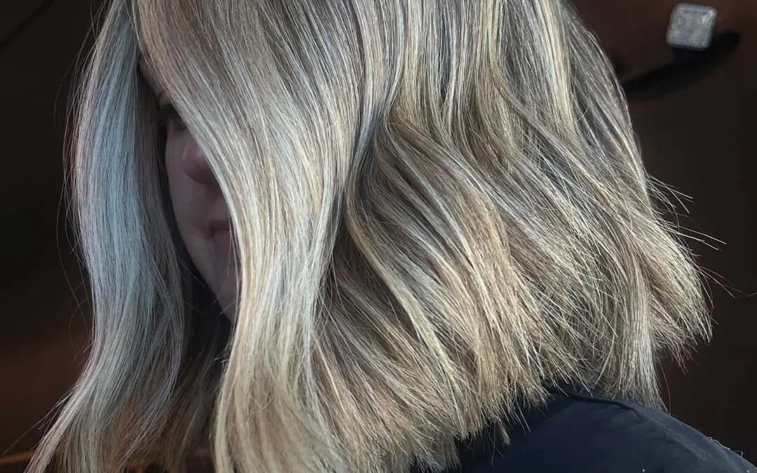 Medium-length, naturally curly hair styled with perfectly defined, bouncy ringlets in a rich chocolate brown hue with warm undertones, expertly shaped by a stylist at Sunday Salon in Raleigh.