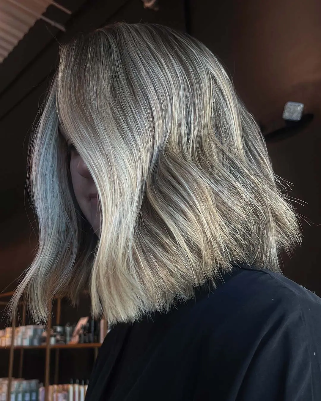 Medium-length, naturally curly hair styled with perfectly defined, bouncy ringlets in a rich chocolate brown hue with warm undertones, expertly shaped by a stylist at Sunday Salon in Raleigh.