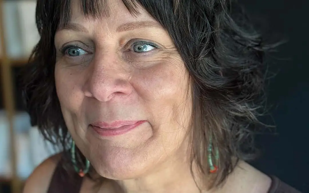 A chic, collarbone-length dark brunette shag haircut featuring soft textured waves and wispy, piecey bangs, custom crafted by an expert stylist at Sunday Salon in Raleigh.