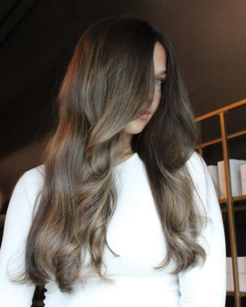 Ultra-Long Ash Brunette Balayage with Soft Waves Ultra-long, thick brunette hair styled in soft cascading waves, featuring a seamless ash brown balayage created by an expert stylist at Sunday Salon in Raleigh.