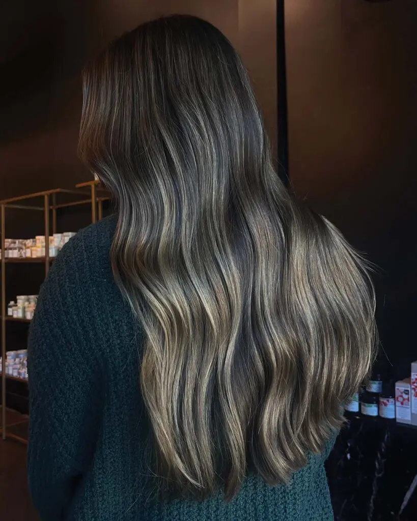 Ultra-Long Dimensional Brunette with Caramel Balayage Ultra-long, dark brunette hair styled in soft, cascading waves with seamless caramel and honey balayage highlights, created by an expert stylist at Sunday Salon in Raleigh.
