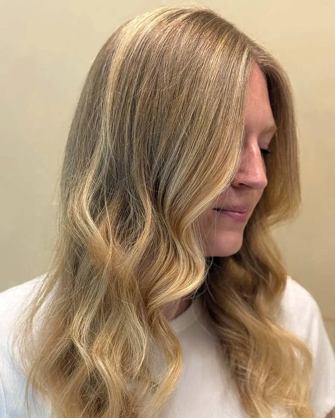 Sun-Kissed Golden Blonde Balayage with Soft Cascading Waves A stunning long blonde hair transformation created at Sunday Salon in Raleigh, featuring seamless golden blonde babylights, subtle dimensional tones, and soft, beachy cascading waves for a natural, effortless finish.