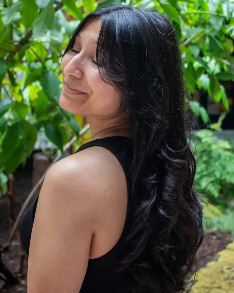 Long espresso brunet waves with seamless face-framing curtain fringe, expertly styled at Sunday Salon located in Raleigh.