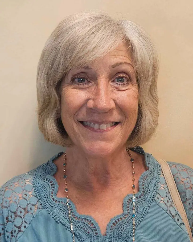 Chin-length platinum blonde bob featuring internal texture and side-swept fringe, expertly styled at Sunday Salon located in Raleigh.