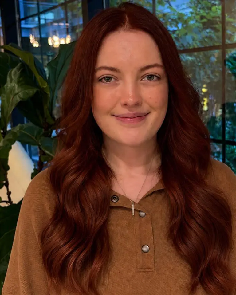 Rich auburn copper hair with soft flowing waves and added volume using extension techniques at Sunday Salon located in Raleigh.