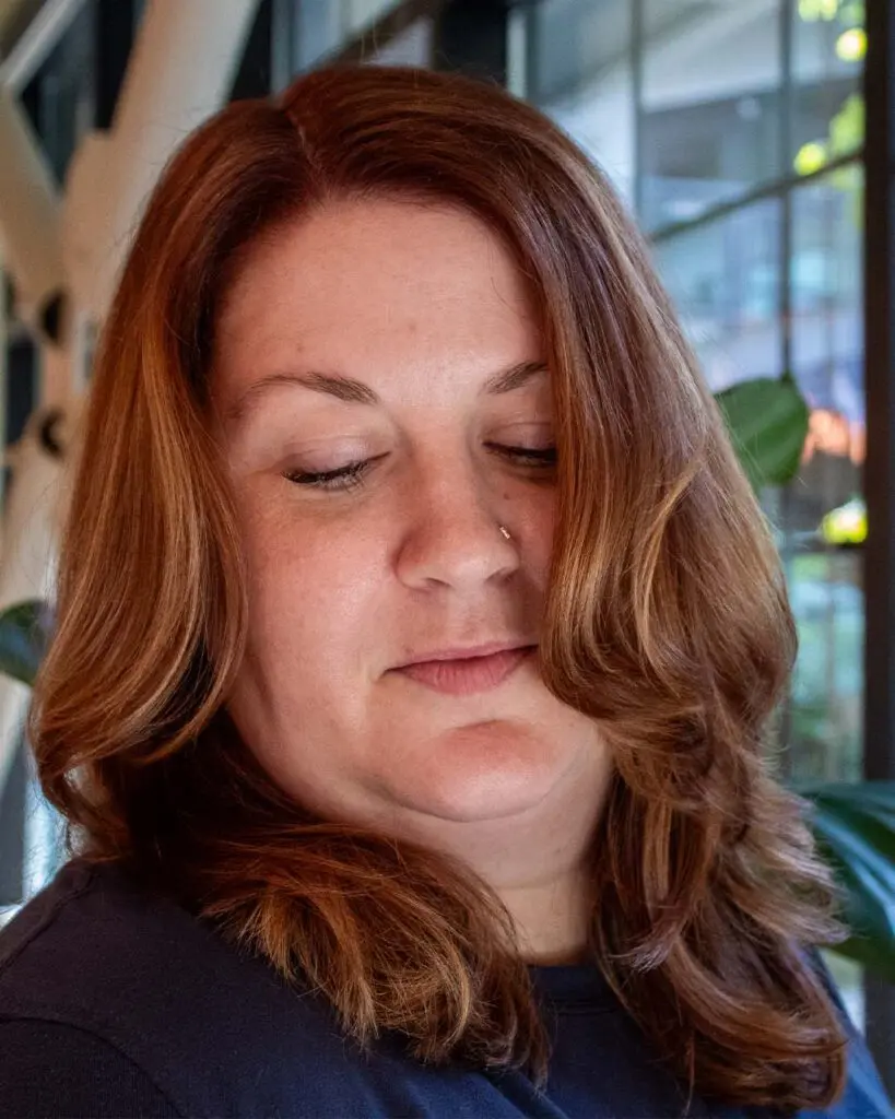 Shoulder-length warm auburn chestnut hair with soft face-framing waves, expertly styled at Sunday Salon located in Raleigh.