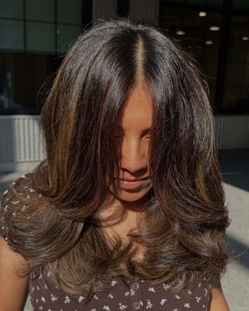 Mid-length warm chocolate espresso balayage featuring glossy dimensional highlights and bouncy curled ends at Sunday Salon in Raleigh.