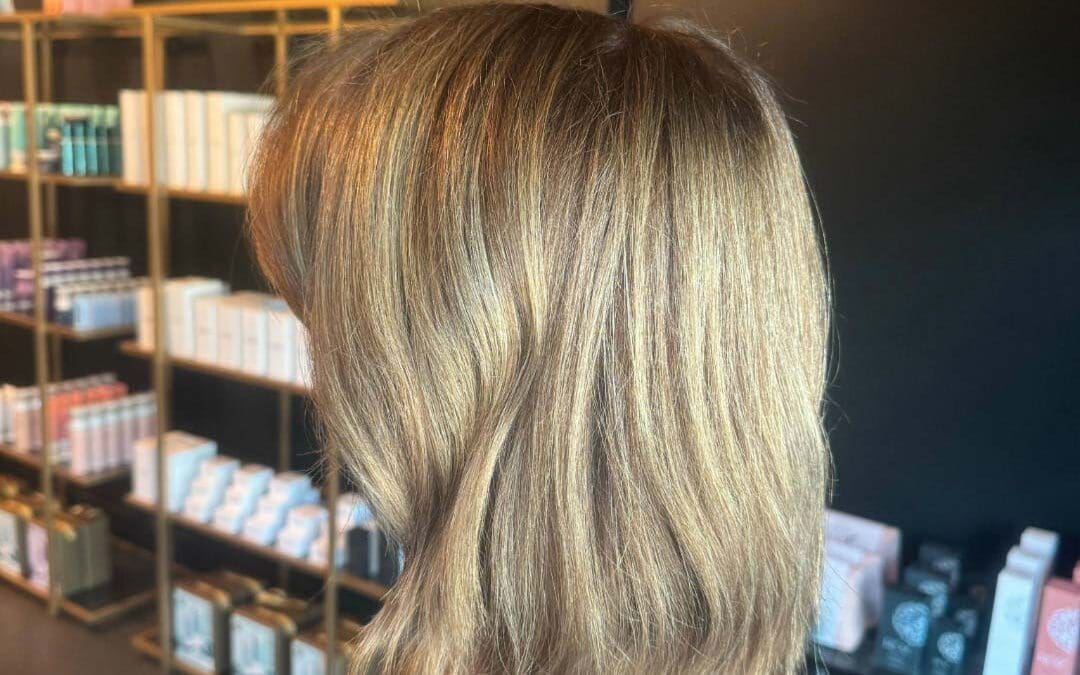 Get a chic hair transformation with honey blonde highlights and a textured lob. Our expert stylists await! Book your appointment at Sunday Salon today!