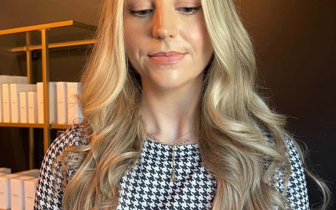 A client at Sunday Salon in Raleigh displaying ultra-long, dimensional blonde hair styled in soft, glamorous waves. The bright, face-framing highlights pop against a subtle, lived-in base, showcasing the elegant flow of the cascading layers and healthy volume.