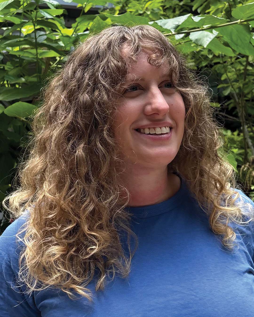 Naturally Defined Golden Blonde Curls with Curly Fringe A long, naturally curly hair transformation featuring defined golden blonde ringlets and full curtain bangs created at Sunday Salon in Raleigh.